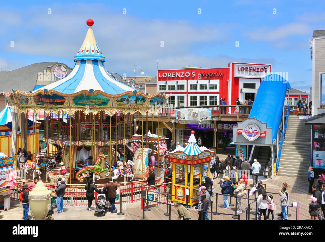Pier 39 Fisherman's Wharf with fairground rides and entertainment busy with tourists on a sunny afternoon Embarcadero San Francisco California USA Stock Photo