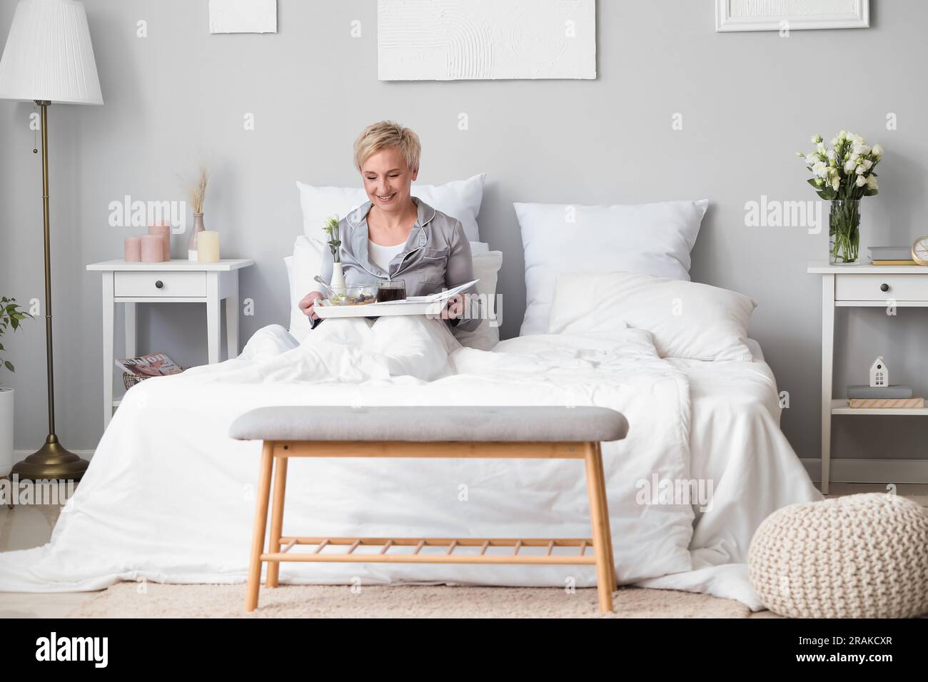 Mature woman having breakfast in bed Stock Photo