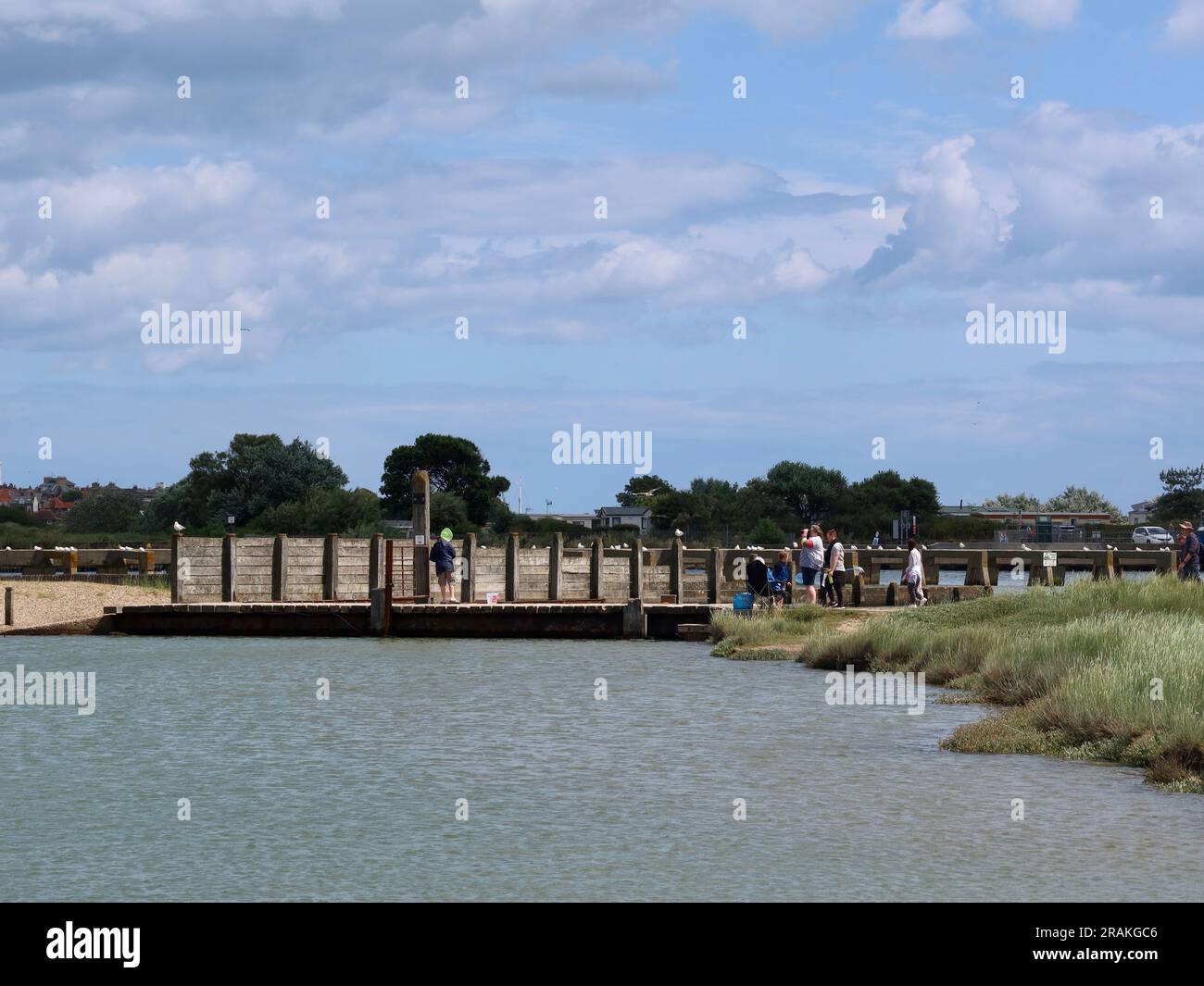 Walberswick, Suffolk - 3 July 2023 : Warm summer afternoon on the English coast. High tide and River Dunwich almost reaching the bridges. Stock Photo