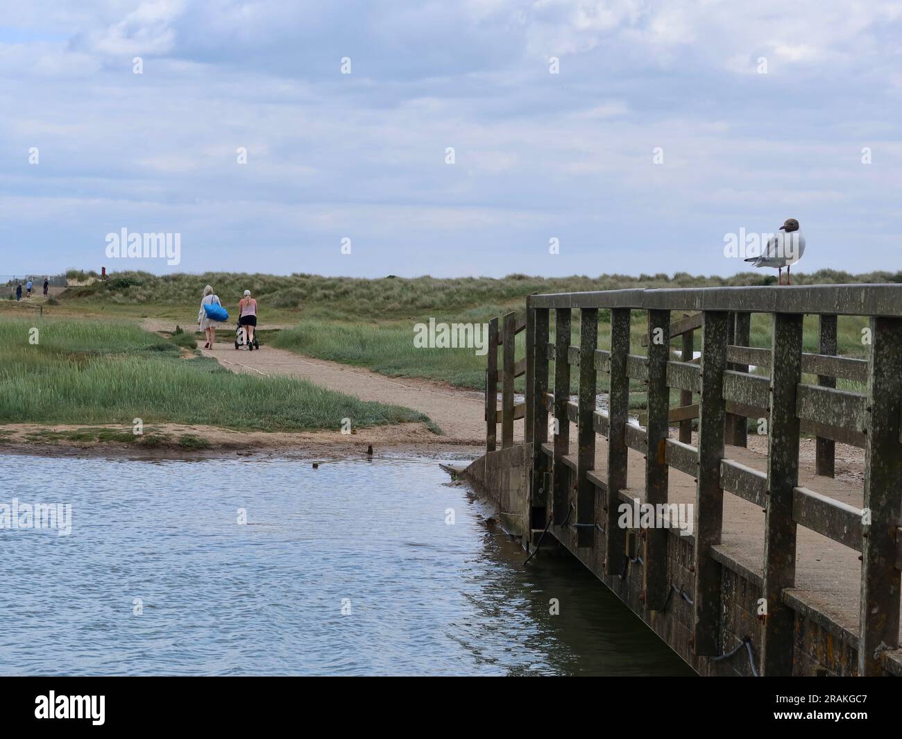 Walberswick, Suffolk - 3 July 2023 : Warm summer afternoon on the English coast. High tide and River Dunwich almost reaching the bridges. Stock Photo