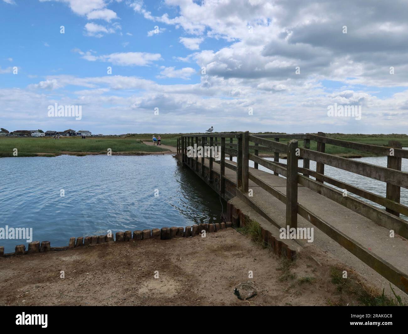 Walberswick, Suffolk - 3 July 2023 : Warm summer afternoon on the English coast. High tide and River Dunwich almost reaching the bridges. Stock Photo