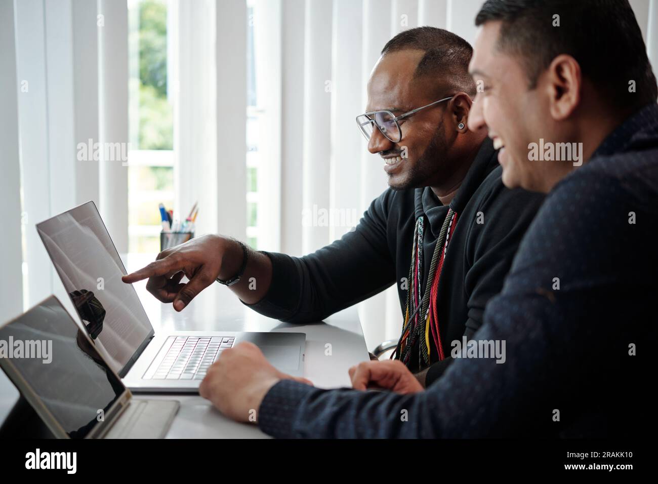 Team of software developers checking programing code on laptop screen Stock Photo