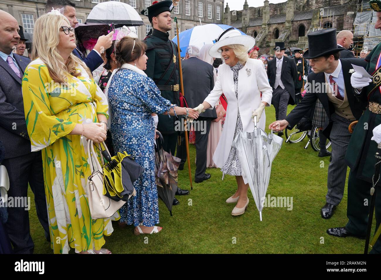 Queen Camilla greets guests during a Garden Party at the Palace of