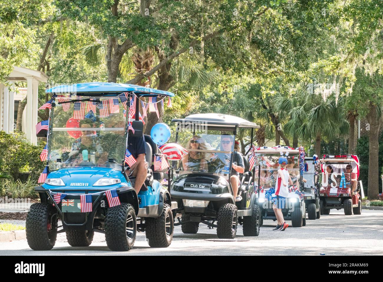 Golf carts decorated in patriotic colors process in the annual Bicycle and Golf cart parade