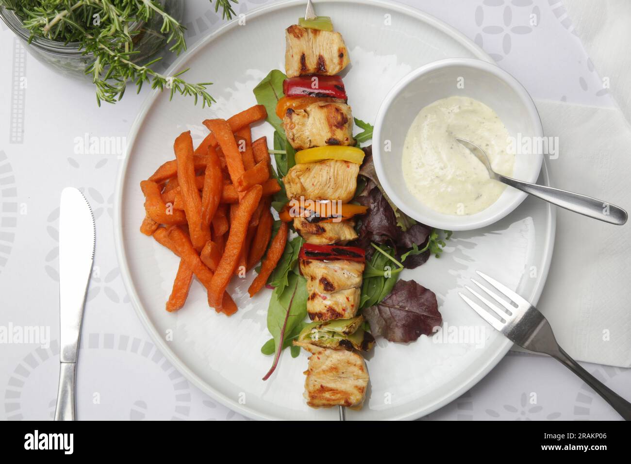 Greek souvlaki, sweet potatoe and tzatziki yogurt dip served on the plate in the restaurant Stock Photo