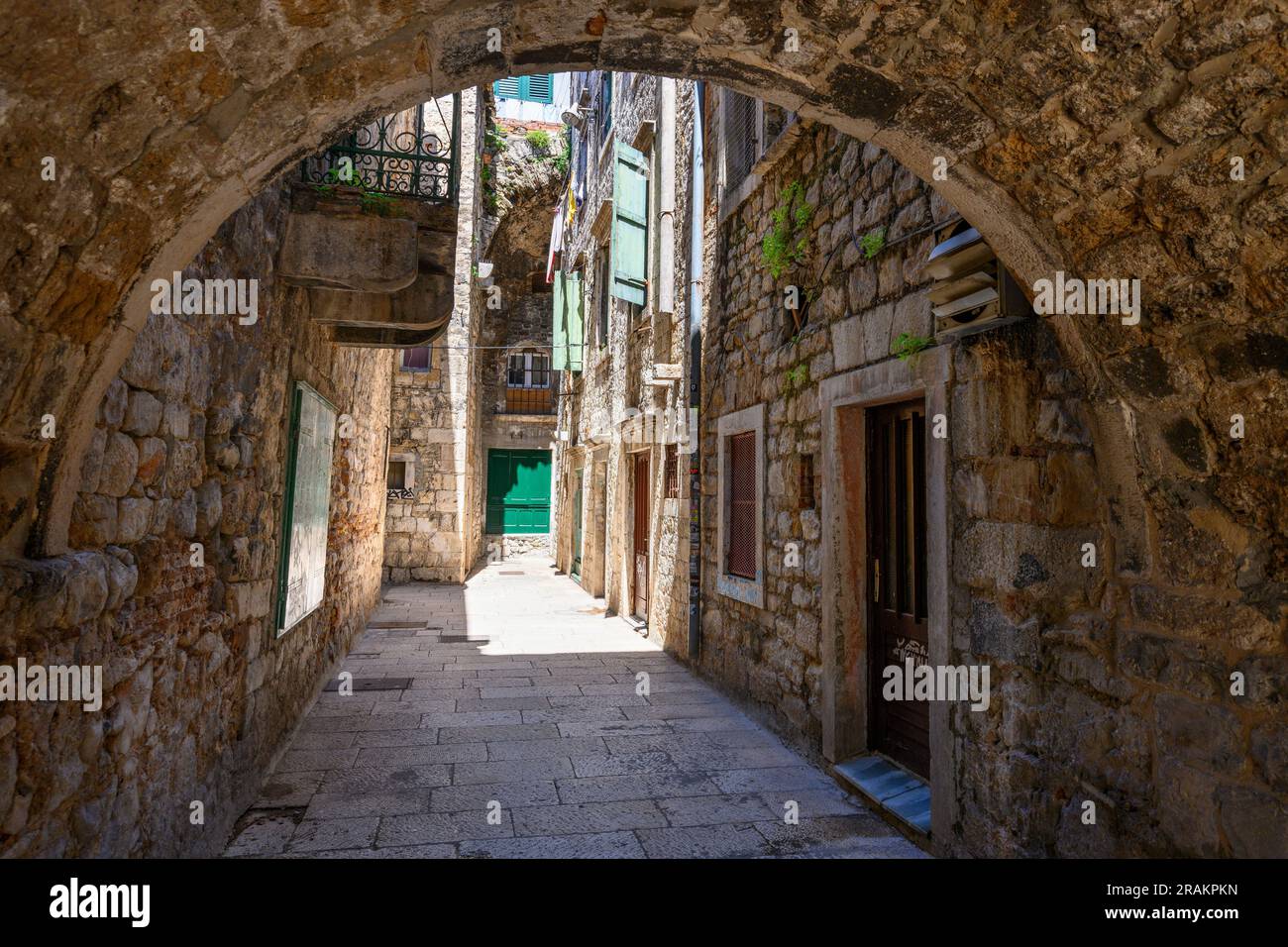 A typical covered, narrow alleyway in the  Medieval old town next to the walls of Diocletian's Palace in Split, Dalmatia, Croatia. Stock Photo