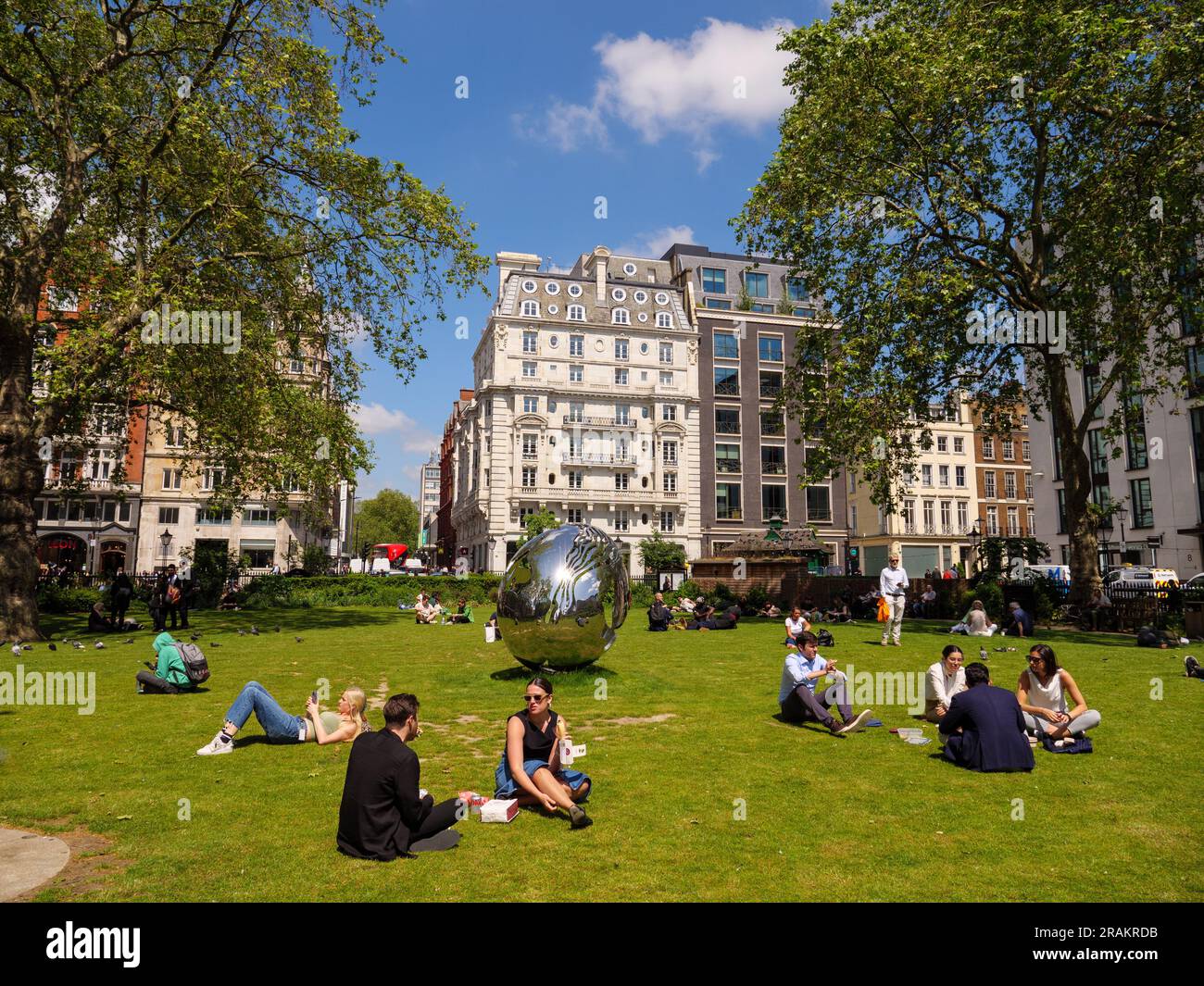 People relaxing on summer day in Hanover Square in central London, UK Stock Photo