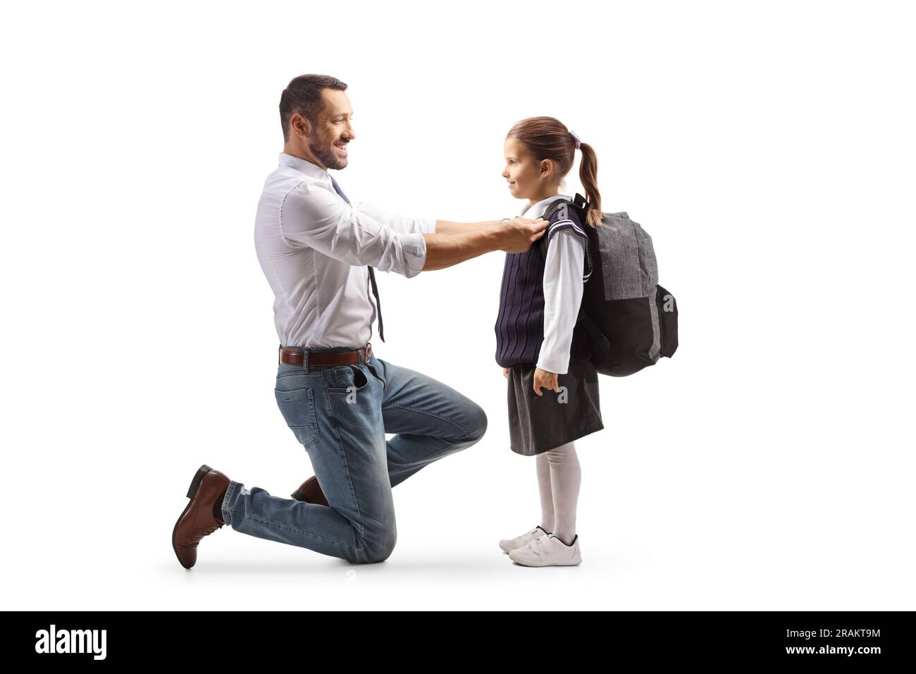 Full length profile shot of a father helping a girl getting ready for school isolated on white background Stock Photo