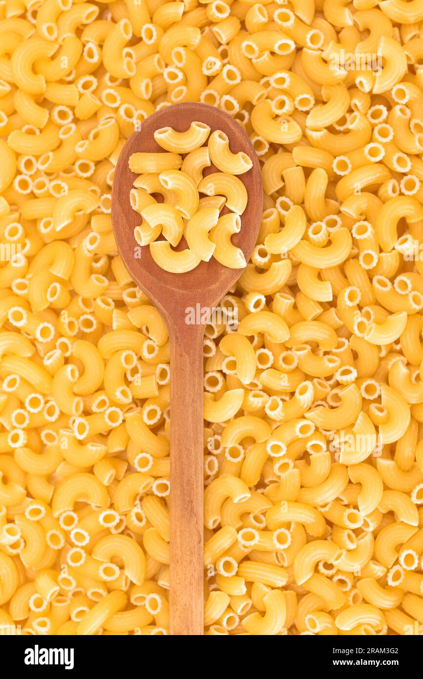 Uncooked Chifferi Rigati Pasta Background with Wooden Spoon. Fat and ...