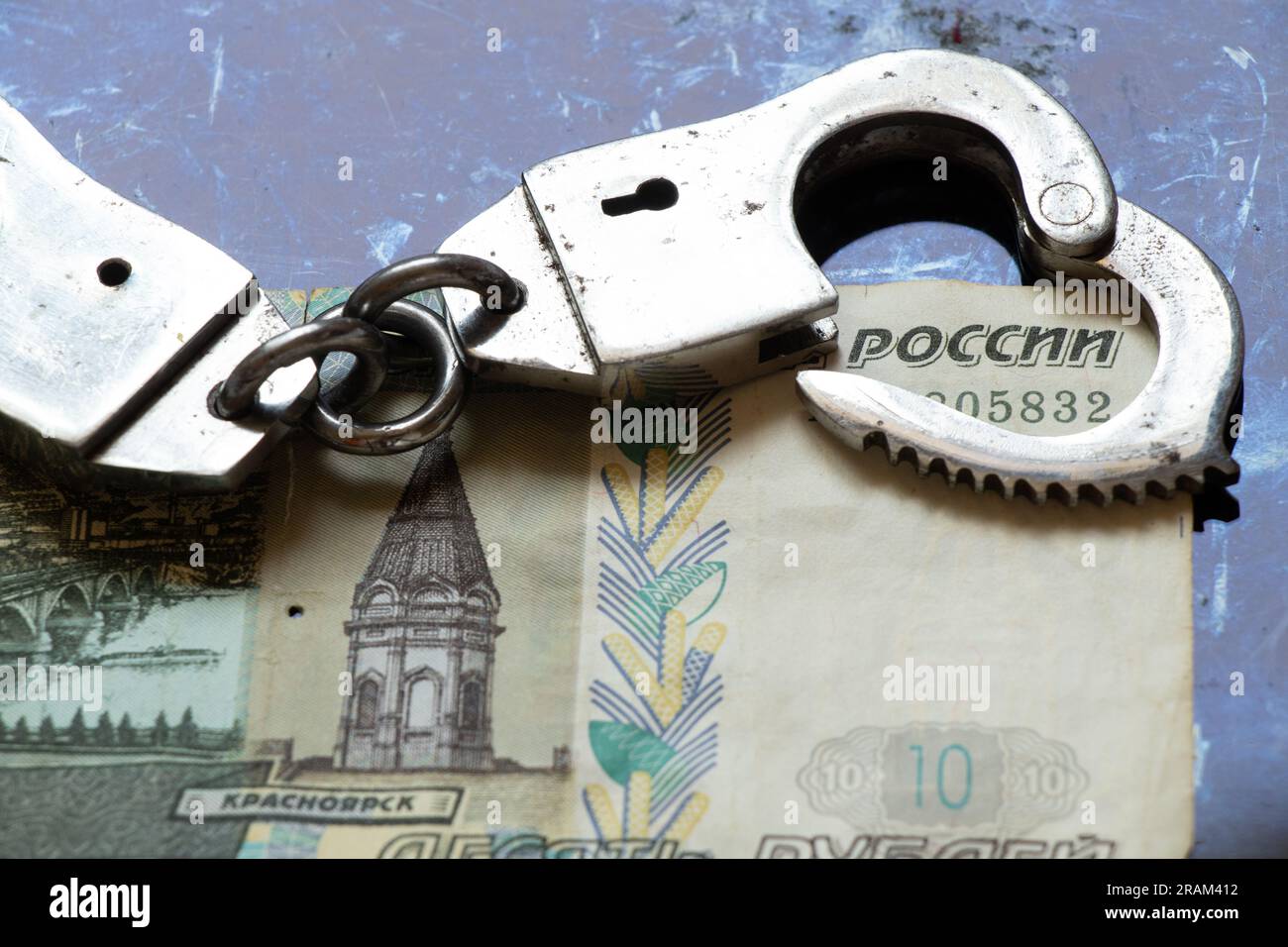 Ten rubles and handcuffs lie on a black background, finance and law, corruption Stock Photo