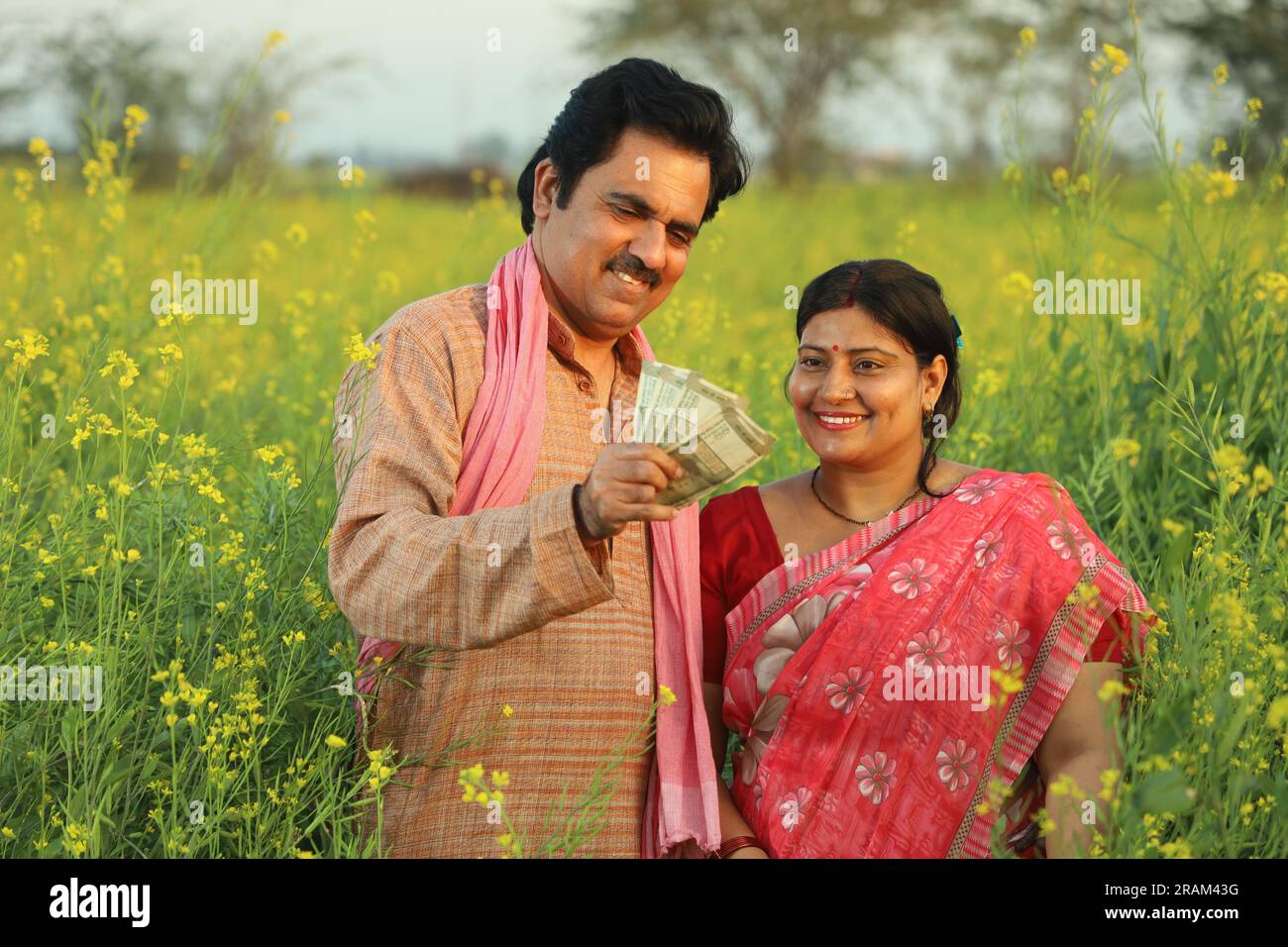Happy Indian farmer couple standing in mustard field enjoying the ...