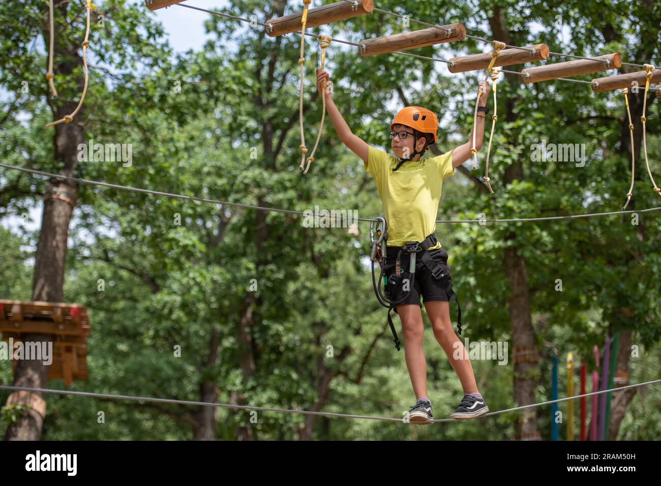 Boy enjoys climbing in the ropes course adventure. Happy boys playing