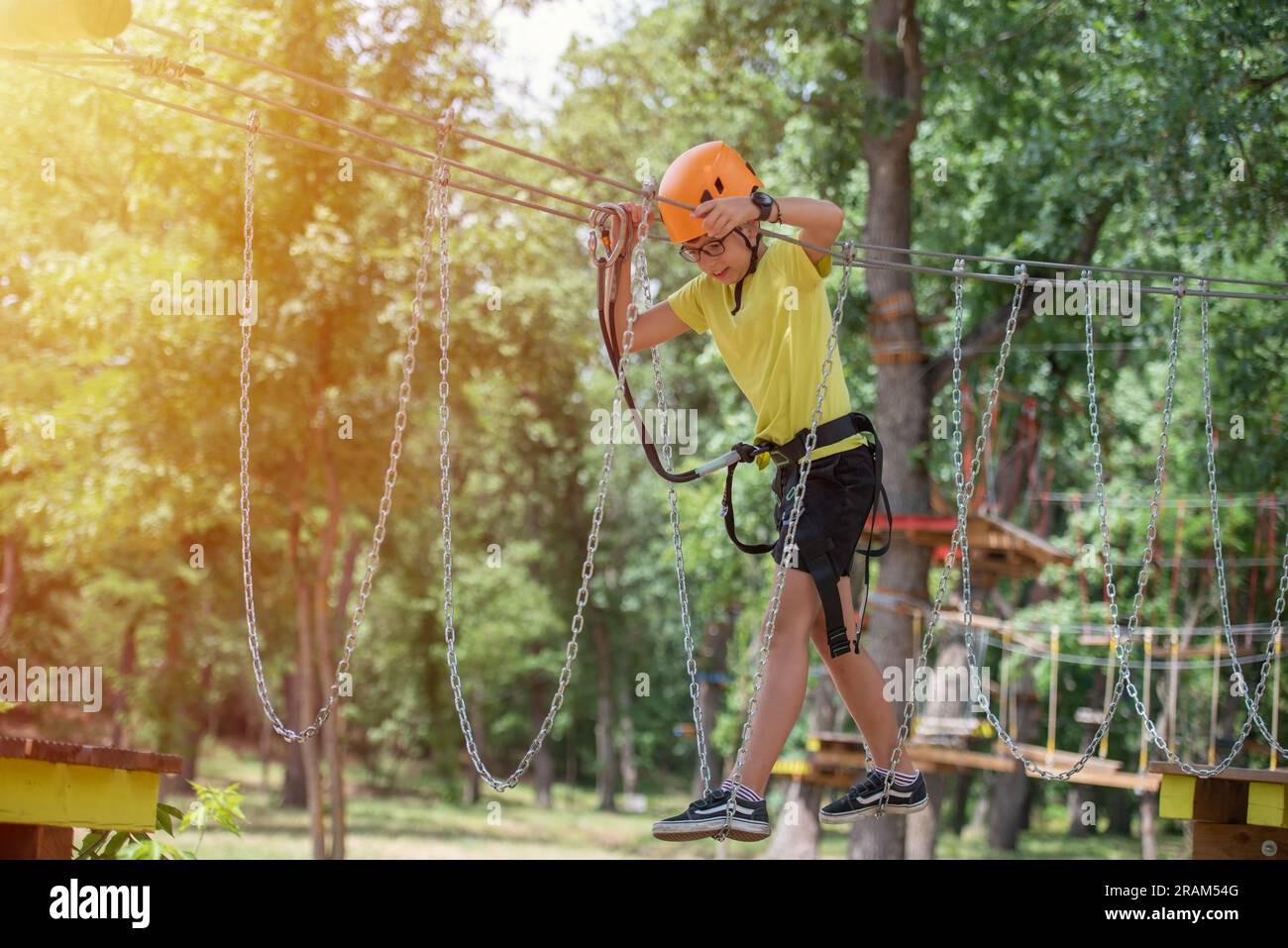 Boy enjoys climbing in the ropes course adventure. Happy boys playing ...