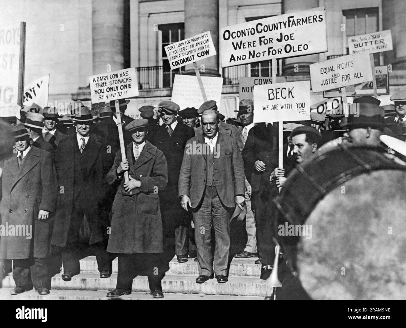 Madison, Wisconsin:  c. 1930 Wisonsin farmers protest the usage and sale of 'synthetic butter' , otherwise known as oleomagarine which was made from vegetable or coconut oils. Supporter and former U.S. Representative and current Commissioner of the Wisconsin State Department of Agriculture Joseph D. Beck stands in their midst. Stock Photo