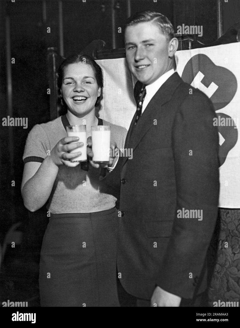 Chicago, Illinois:  December 4, 1934 The boy and girl 4-H Clubs health champions of 1934, Doris Paul of Wilton Junction, Iowa and Leland Monasmith of Lane, South Dakota, enjoy glasses of milk together. Stock Photo