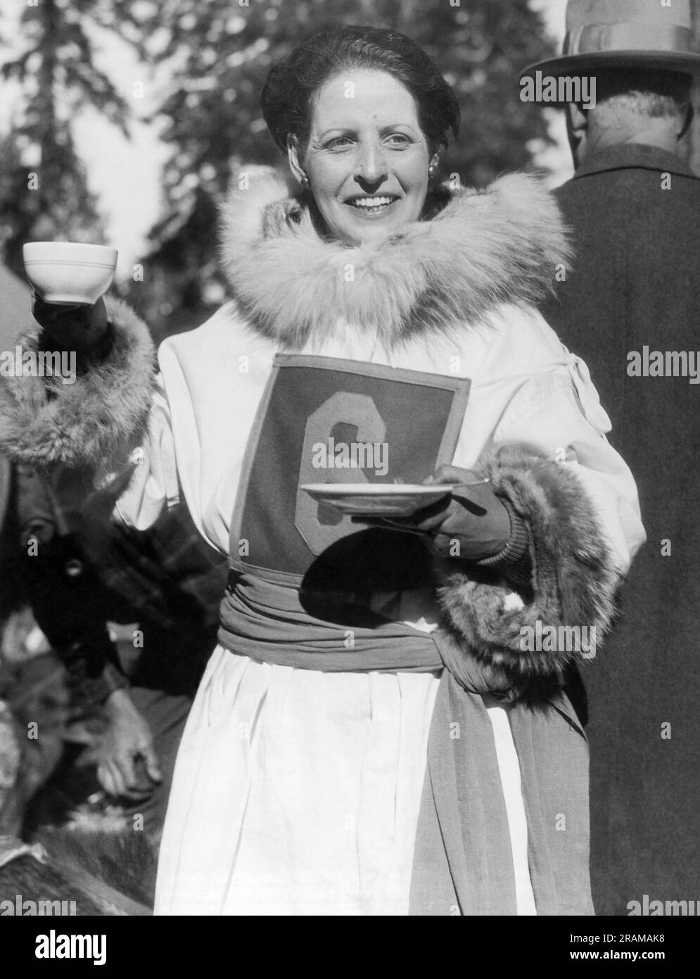 Ashton, Idaho:  c. 1928 Lydia 'Whistling Lyd' Hutchinson, sled dog racer who is noted for training her dogs by whistling at them rather than using vocal commands. Here she is holding up the coveted 'Kaw-fee Cup' prize that goes to the dog sled race winner. Stock Photo