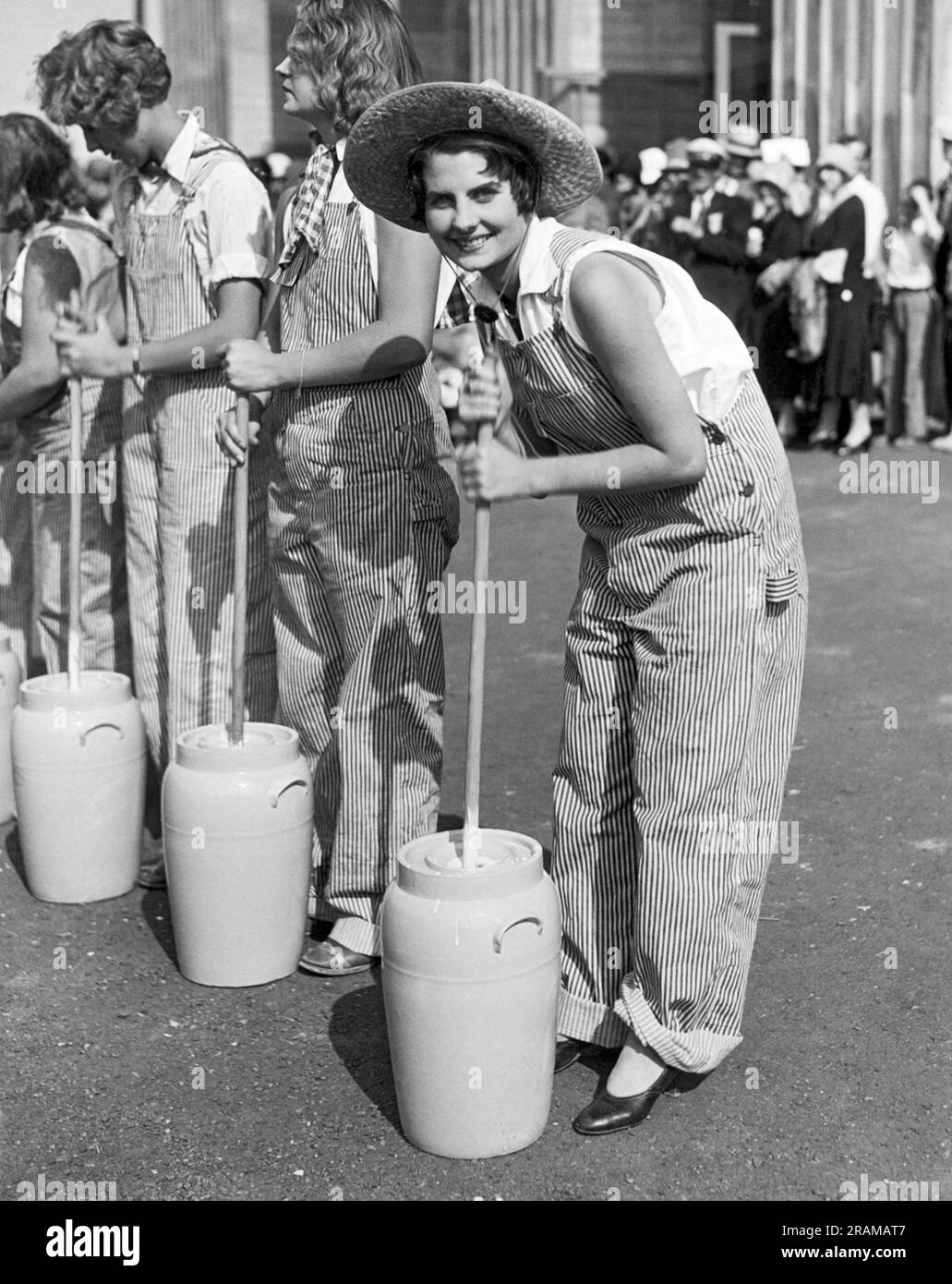 Pomona, California:  c. 1930 Lucille Gates is this year's winner of the American Farm Girl Championships being held at the Los Angeles County Fair. Here she is in action during the butter churning event. Stock Photo
