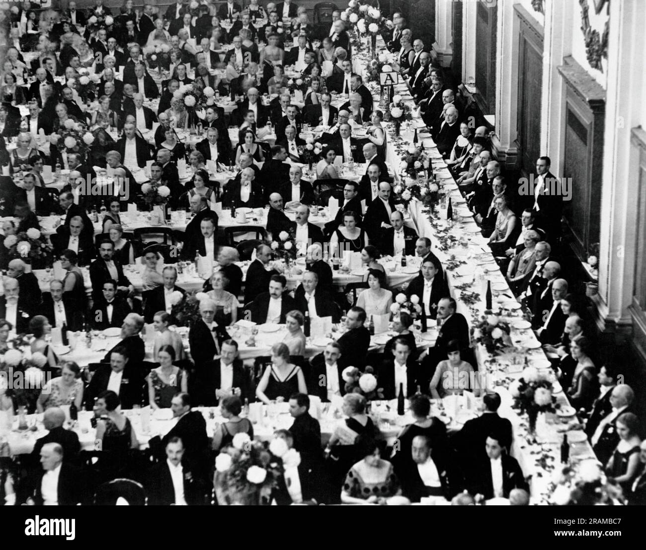 London, England:  1930 The Royal Geographical Society celebrates its 100th anniversary with a spectacular dinner attended by the Prince of Wales. He is directly on front of the man standing on the right. Stock Photo