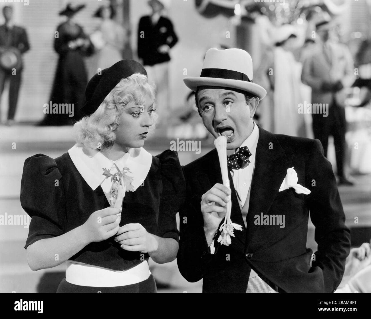 Hollywood, California:  1936 Sammy White eats a stalk of celery as Marion Davies looks on in a scene from the film 'Cain And Mabel' Stock Photo