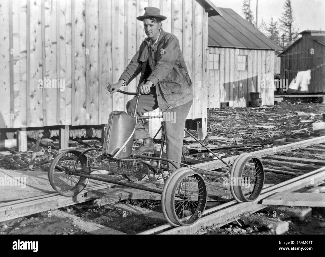 Hoquiam, Washington:  c. 1931. John Lamey got tired of walking the 5 miles to town every day, so he converted his bicycle into a pedal-locomotive equipped with four papier-mache wheels. Stock Photo