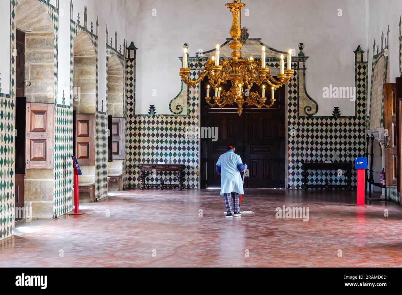 A maid dusts the floor at the Swan Hall or Great Hall with decorated ceiling panels painted with crowned swans at the Sintra National Palace in Sintra, Portugal. The Romanticist architectural and fairytale palaces draws tourists from around the world. Stock Photo