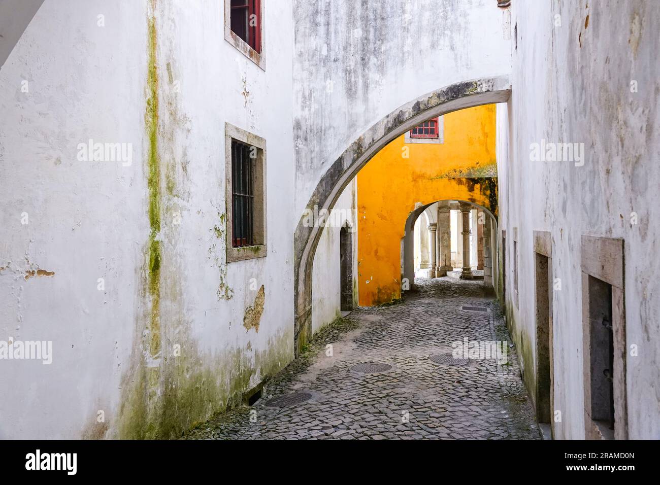 The carriage entrance under the historic Sintra National Palace or in Palácio Nacional de Sintra in Sintra, Portugal. The Romanticist architectural and fairytale palaces draws tourists from around the world. Stock Photo