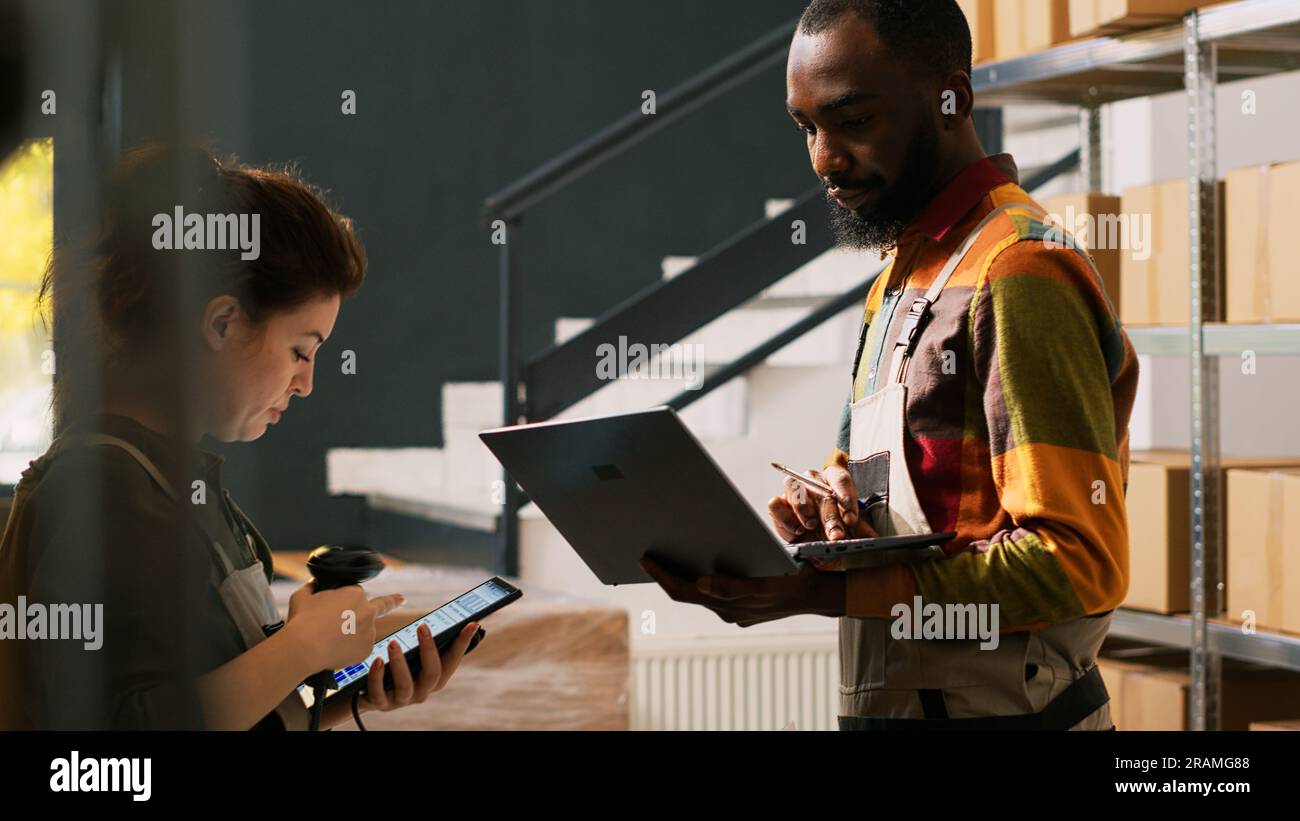 Depot workers reviewing goods on shelves, checking inventory list on