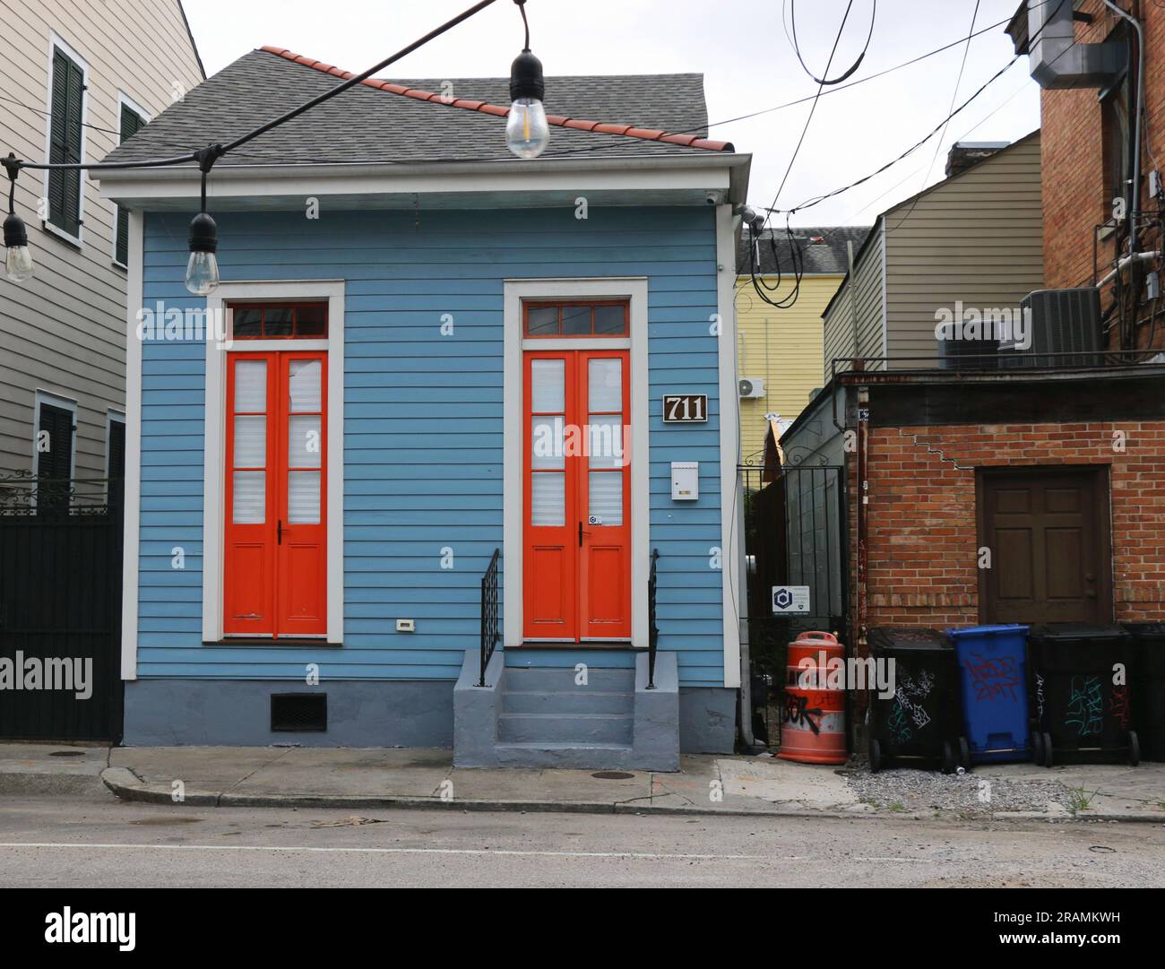 Tiny, quaint blue Creole cottage with bright orange doors in the historic district of Faubourg Marigny, New Orleans. Stock Photo