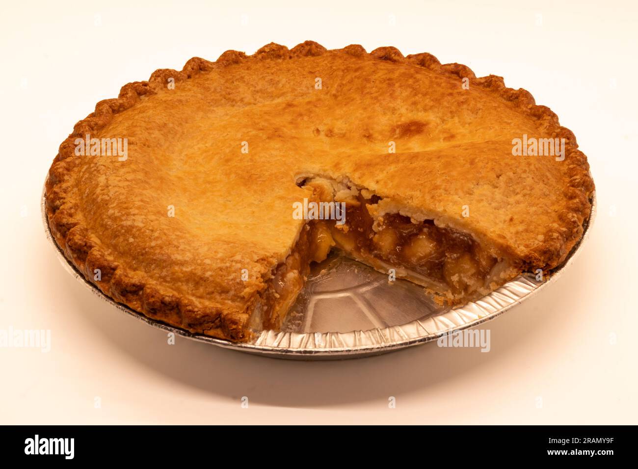 One double-crusted chunky apple pie with one slice missing, in a tin and isolated. Stock Photo