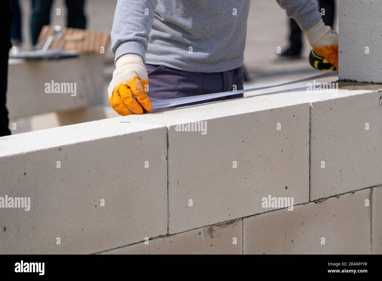 The bricklayer works to measure. Measuring with a meter Stock Photo
