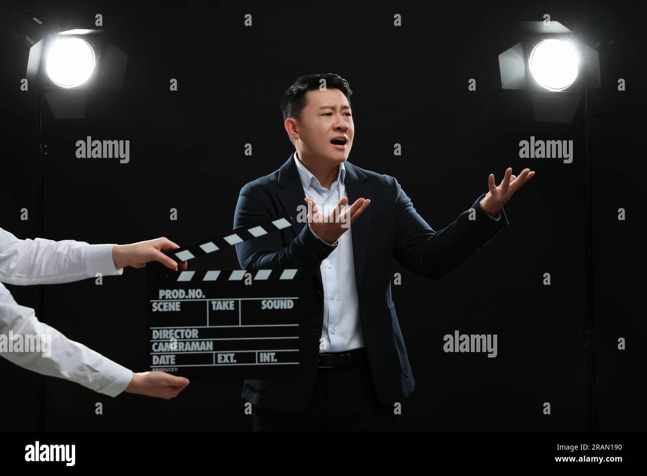 Emotional asian actor performing while second assistant camera holding ...