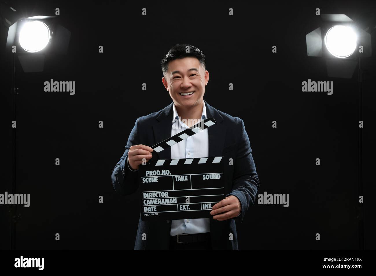 Happy asian actor with clapperboard on stage. Film industry Stock Photo
