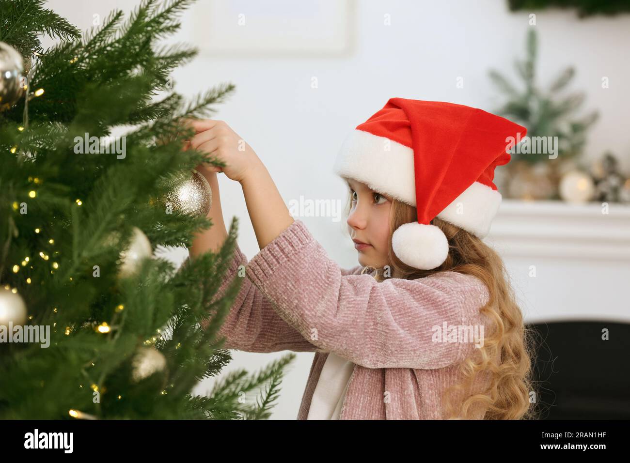 Cute little girl decorating Christmas tree at home Stock Photo - Alamy