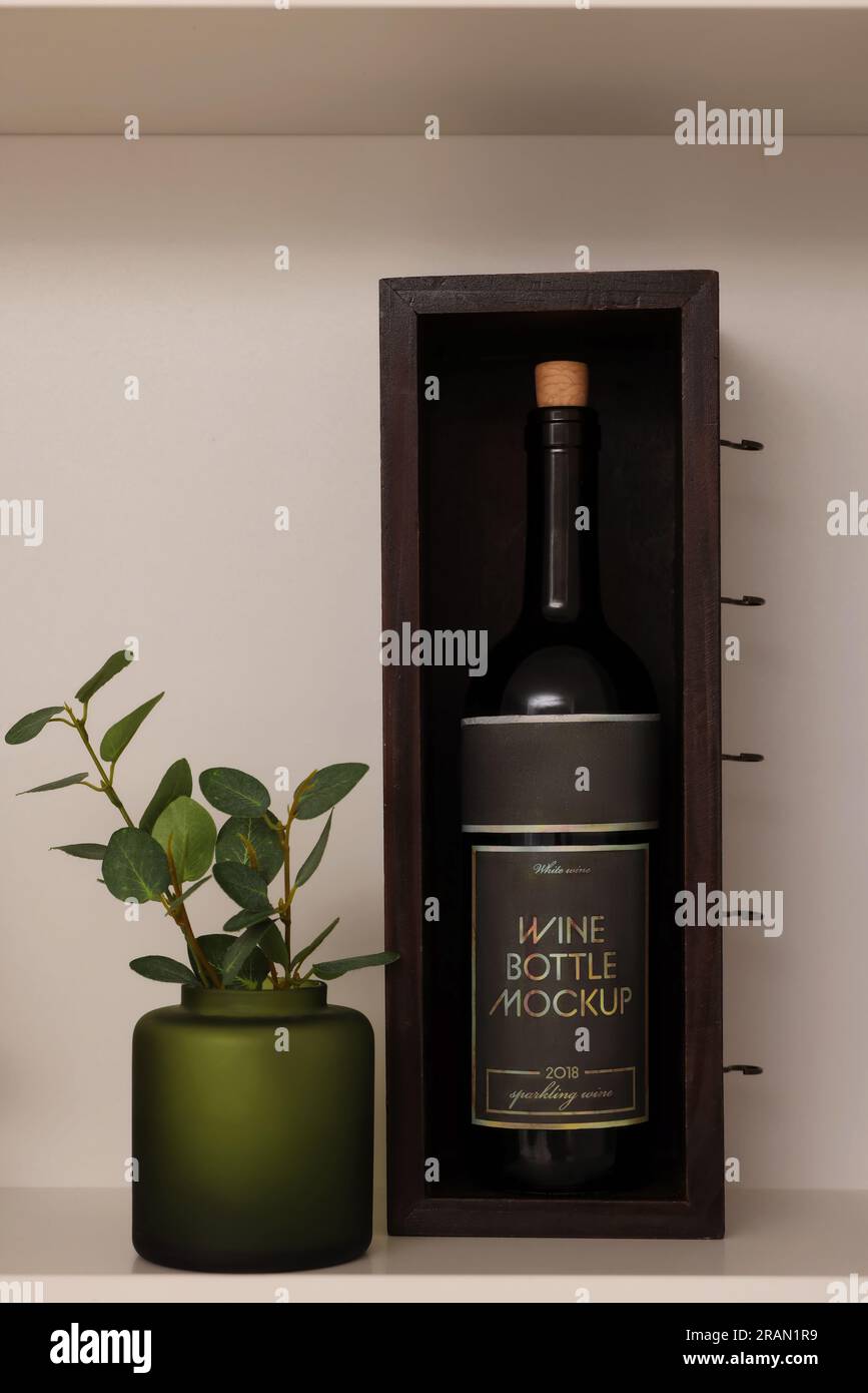 Shelf with houseplant and wine bottle near beige wall. Interior design ...