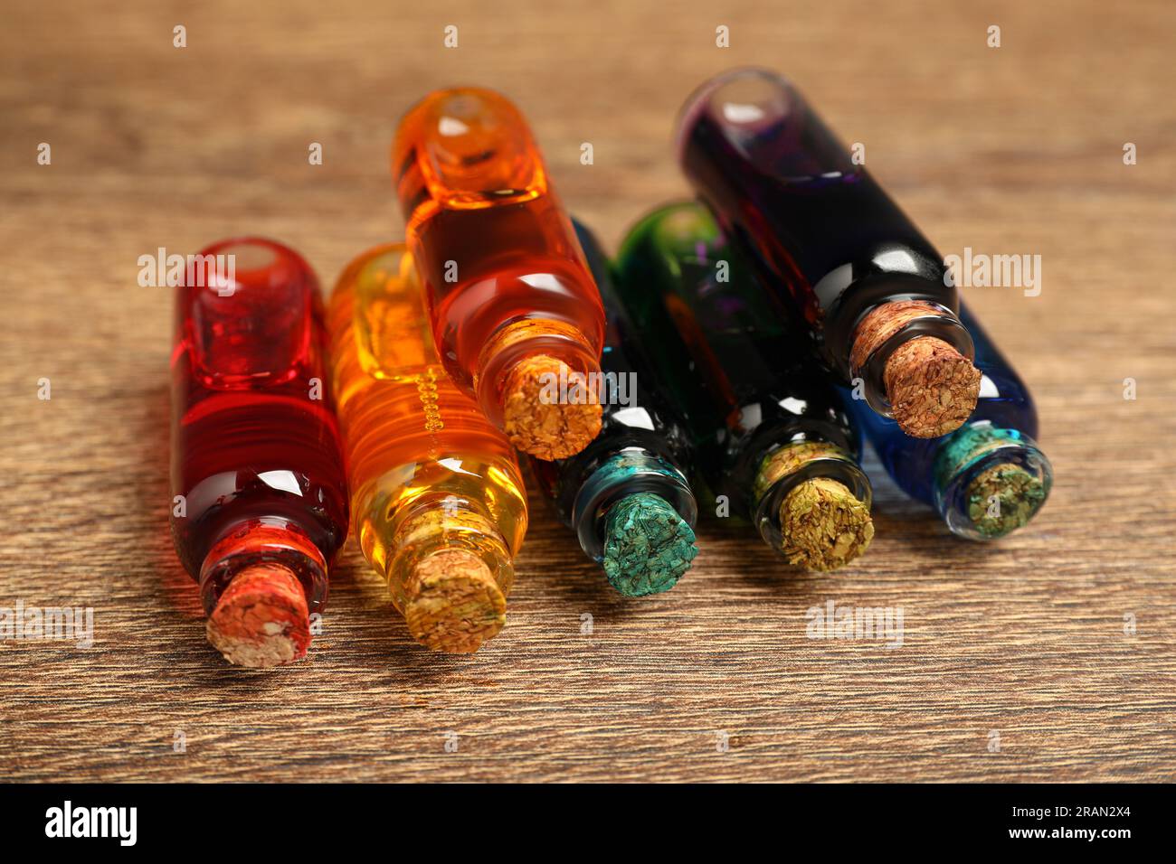Bottles with different food coloring on wooden background, closeup Stock Photo