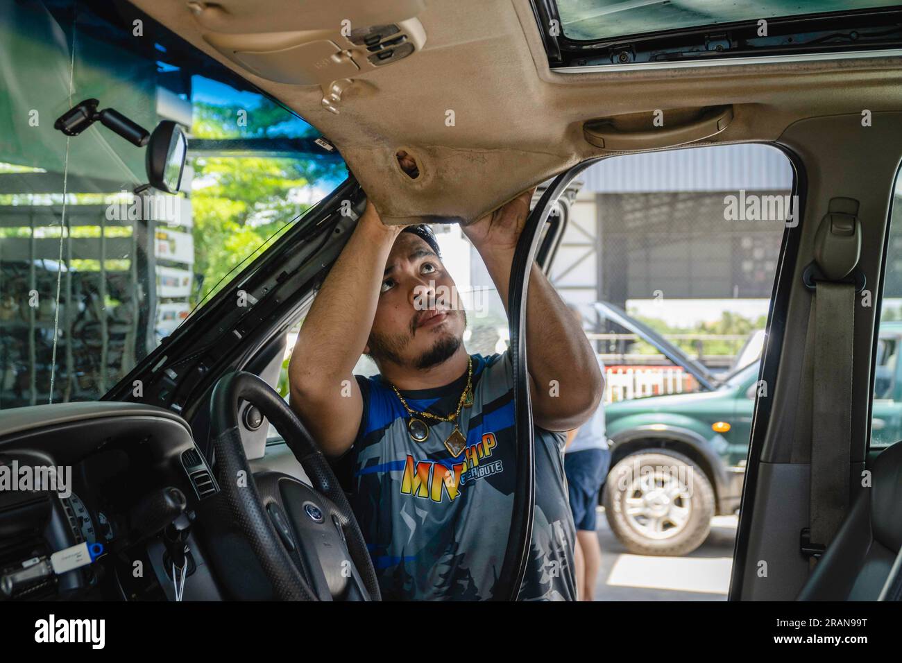 Bang Yai, Nonthaburi, Thailand. 29th June, 2023. A mechanic from a local car repair shop is seen fixing the rubber of a car door, in Bang Yai City. As the original car service centers are expensive, a large range of car users has recourse to local car repair shops in Thailand where it is possible to fix the defective part, bring your own spare part, or buy unbranded spare ones. (Credit Image: © Nathalie Jamois/SOPA Images via ZUMA Press Wire) EDITORIAL USAGE ONLY! Not for Commercial USAGE! Stock Photo