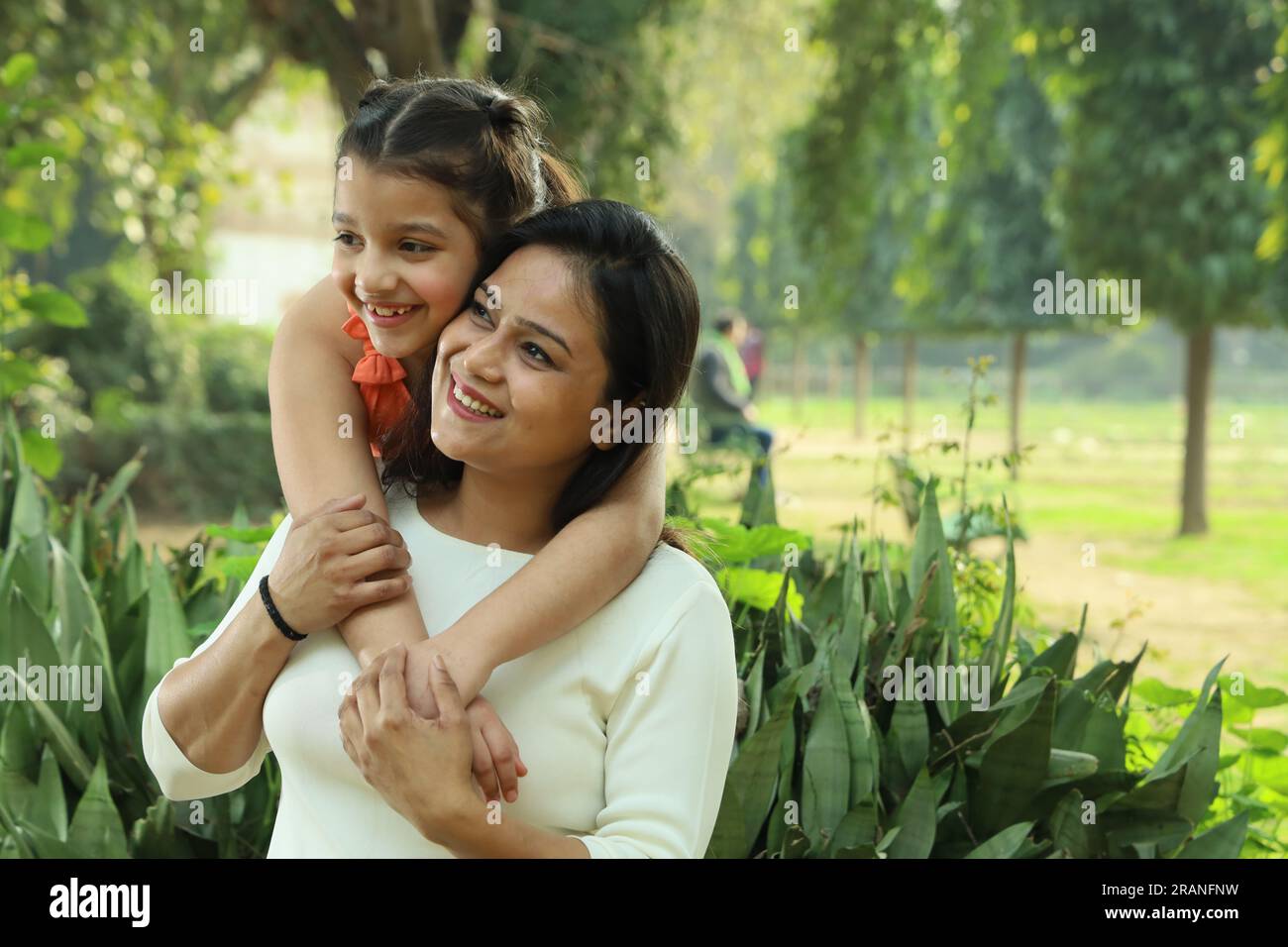 Mother and daughter enjoying in park surrounded with greenery and serenity. They are having joyful and cheerful time together in green environment. Stock Photo