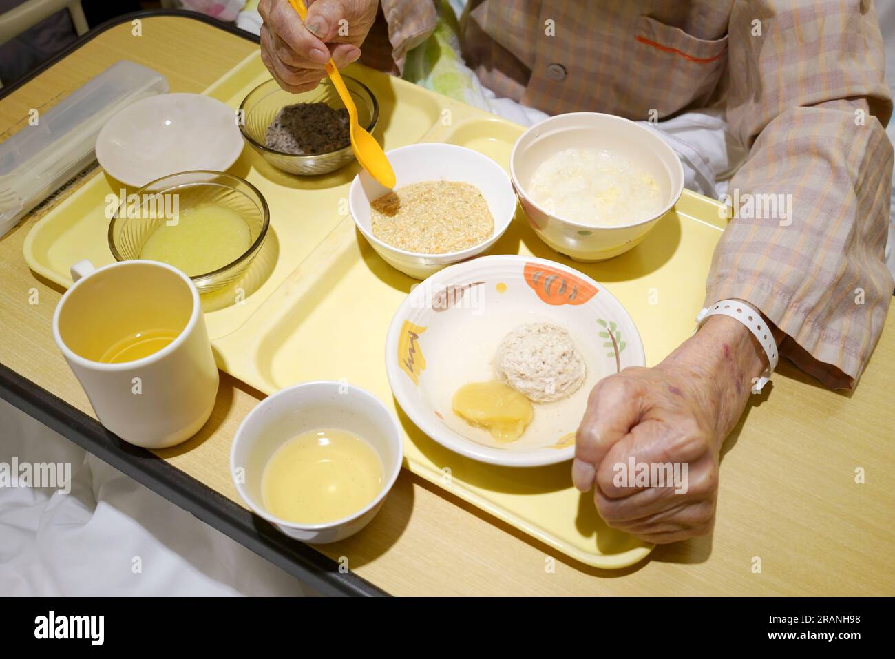 Asian elderly patient with hospitalization eating food for patient on bed in hospital Stock Photo