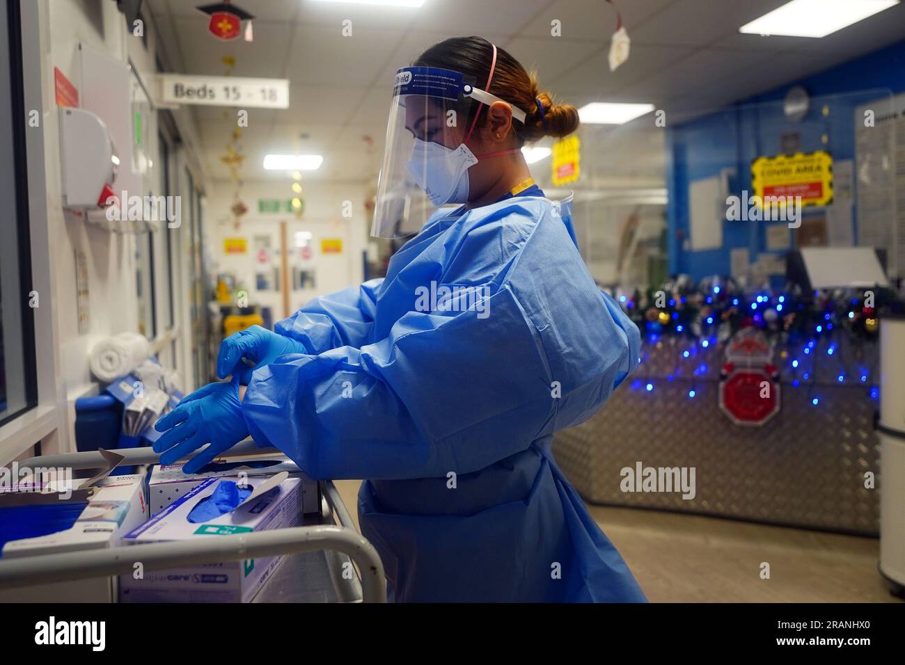 File photo dated 21/12/21 of a nurse putting on full PPE on a ward for Covid patients at King's College Hospital, in south east London. The Government wasted billions of taxpayers' money on unusable personal protective equipment (PPE) and has an 'alarming' lack of plan for an emergency stockpile for future pandemics, MPs have warned. Issue date: Wednesday July 5, 2023. Stock Photo