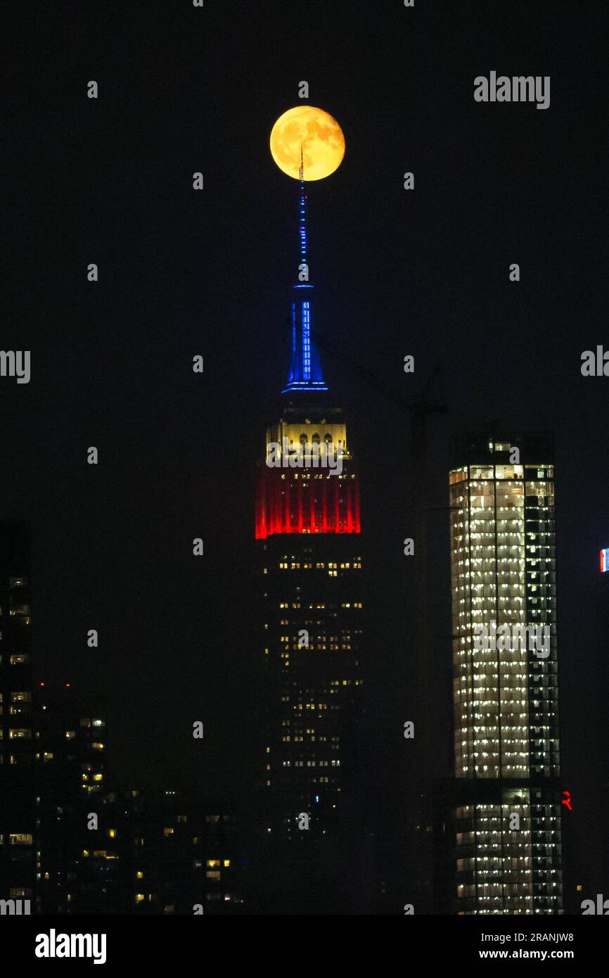 New York City, United States. 04/07/2023, Full moon rises behind Empire ...