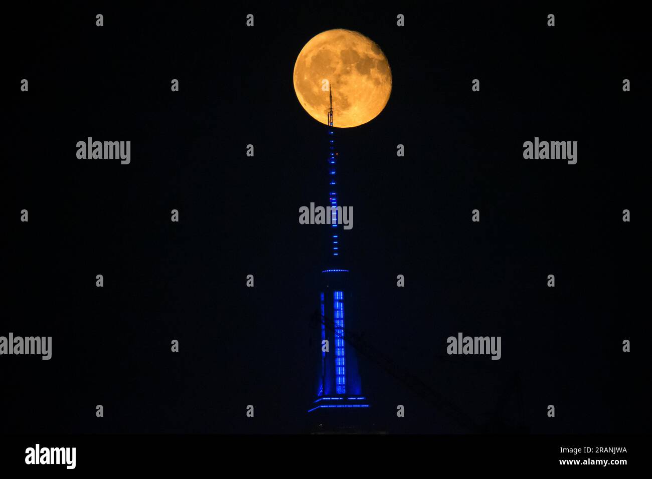 New York City, United States. 04/07/2023, Full moon rises behind Empire ...