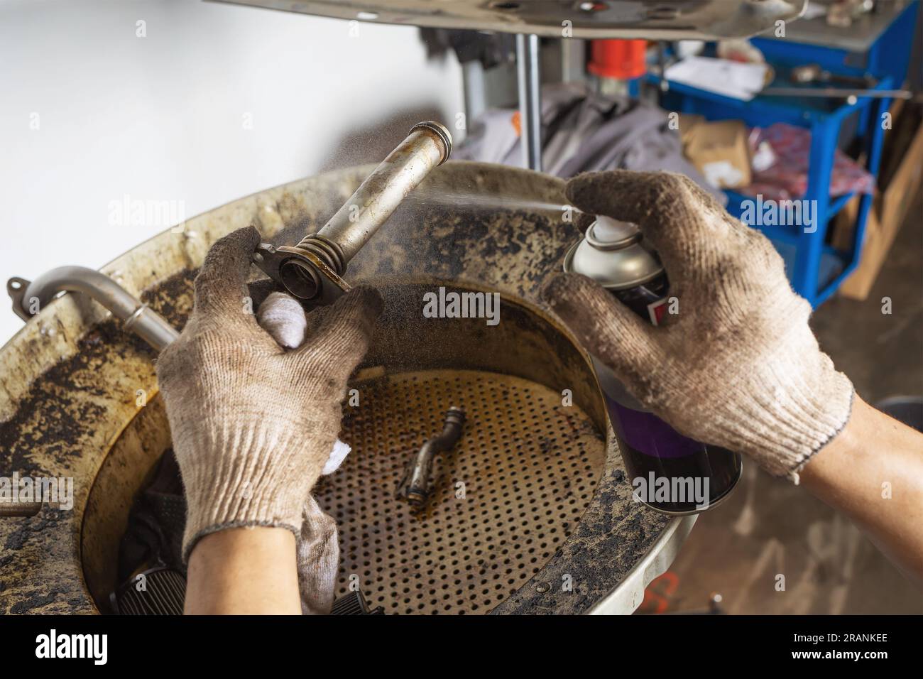 Auto mechanic using a spray to clean the parts of the heat exchanger of a car Stock Photo