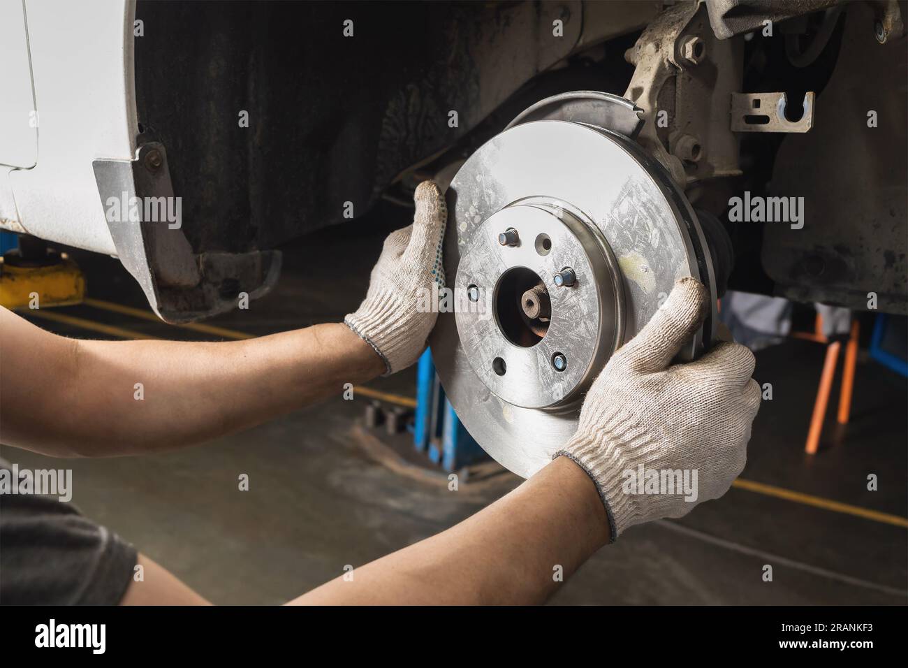 Auto mechanic installs new brake discs for the brake system of a