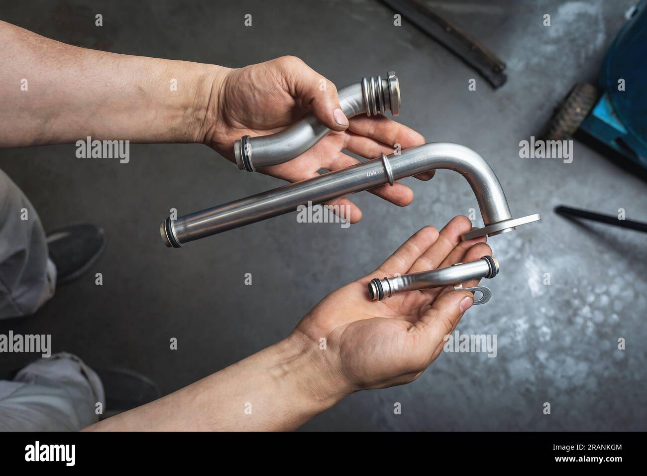 An auto mechanic holds in his hands the cleaned parts of a heat exchanger for a car engine Stock Photo