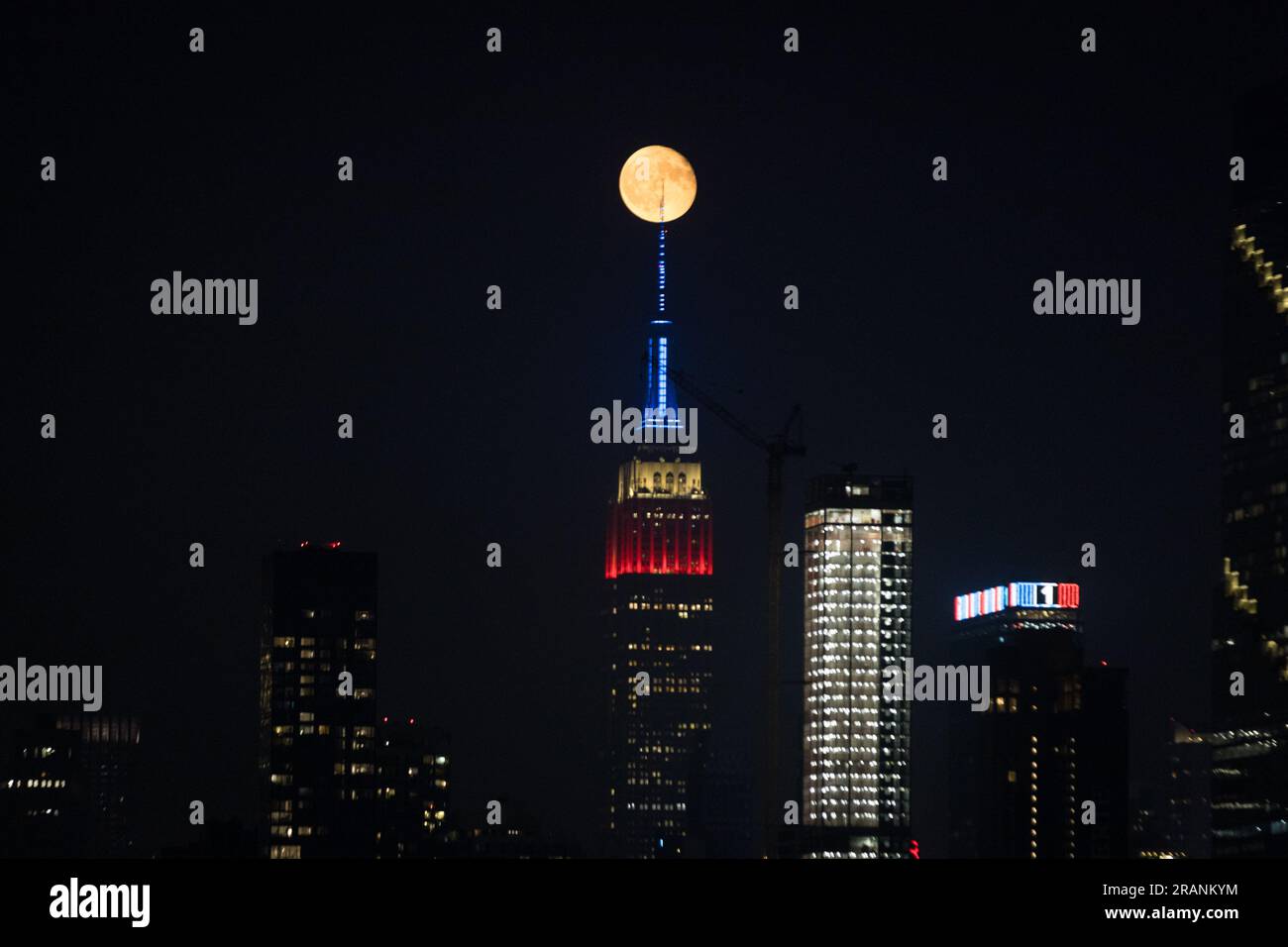 New York City, United States. 04/07/2023, Full moon rises behind Empire ...