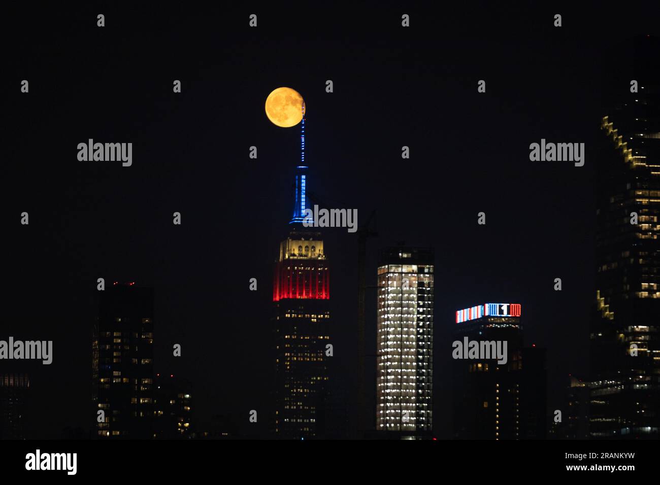New York City, United States. 04/07/2023, Full moon rises behind Empire ...