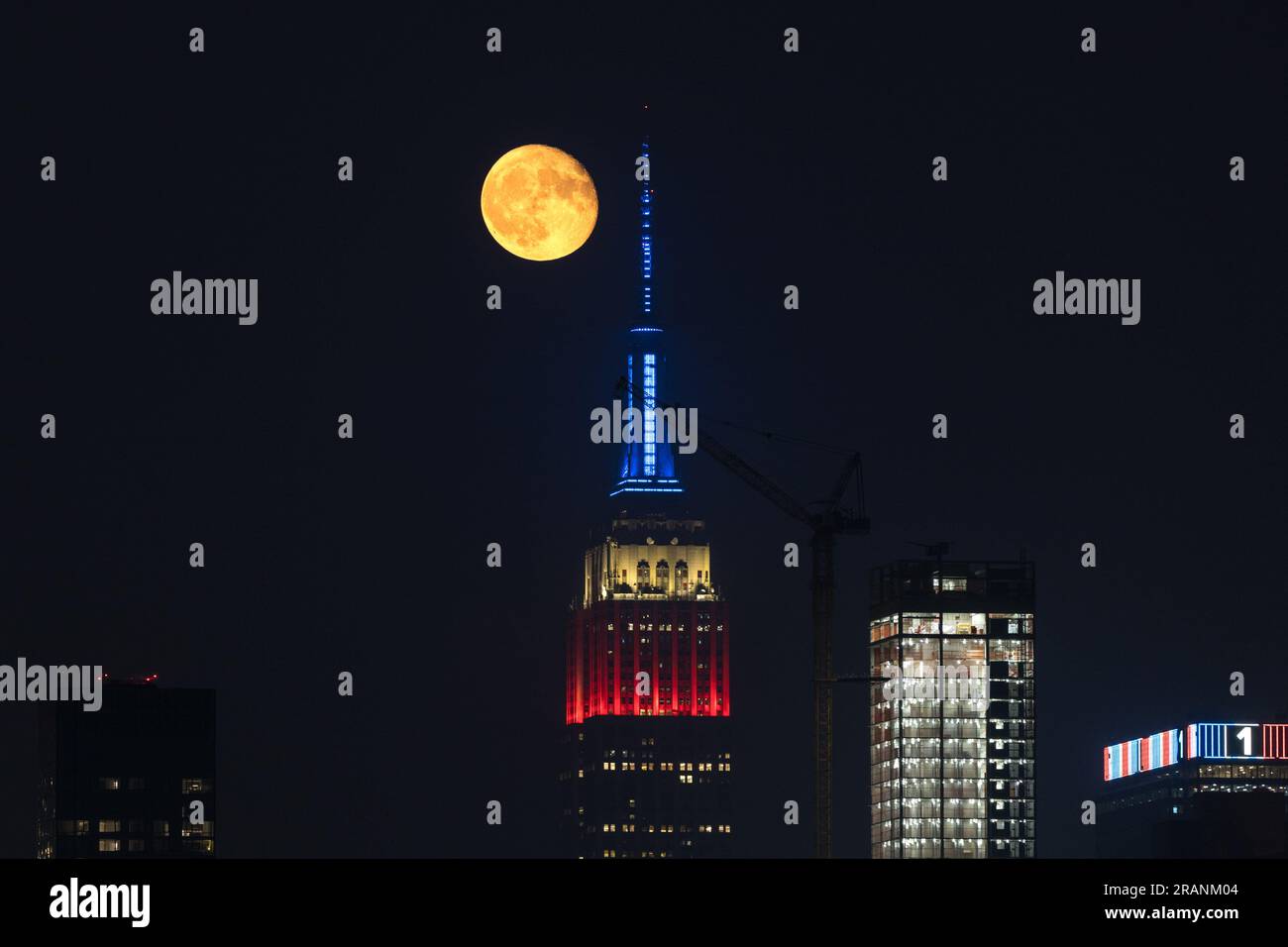 New York City, United States. 04/07/2023, Full moon rises behind Empire ...