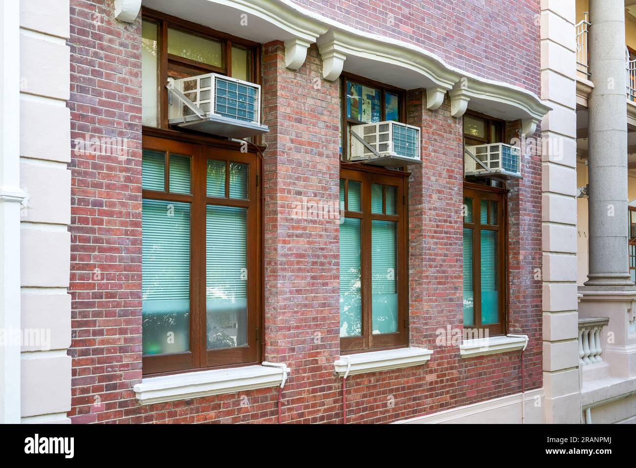 Closeup of an air conditioner window unit installed on a window of a residential building in