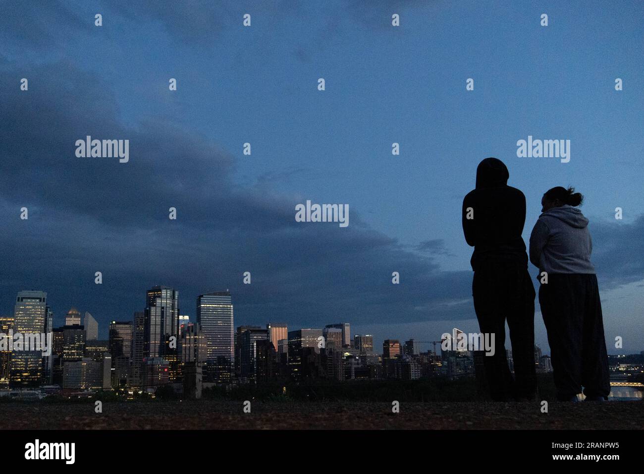Calgary, Alberta, Canada. 5th July, 2023. A couple looks out over downtown Calgary, Canada, at sunset. (Credit Image: © Matias Basualdo/ZUMA Press Wire) EDITORIAL USAGE ONLY! Not for Commercial USAGE! Stock Photo