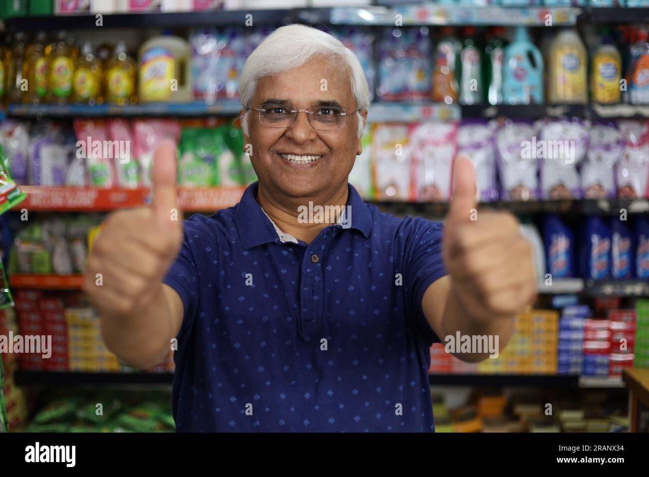 Portrait of Happy and smiling Indian old age man purchasing in a grocery store. Confident and fit Grandpa buying grocery for home in a supermarket. Stock Photo